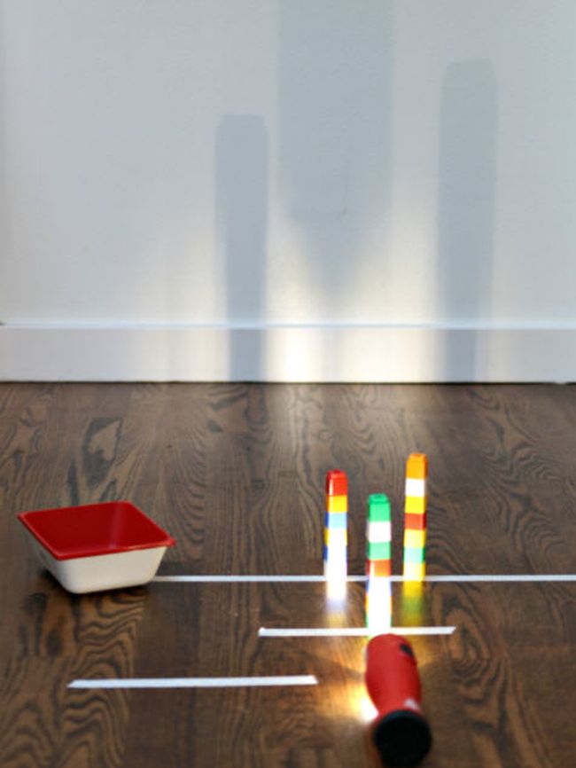 Flashlight shining onto towers made of toy bricks, casting a tall shadow (STEM Activities)