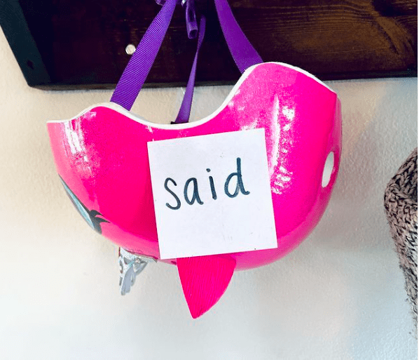 Sticky note with the sight word "said" stuck to a pink child's bike helmet