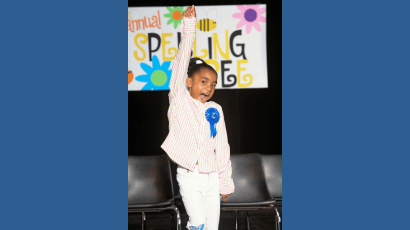 Young Black girl celebrates winning her school spelling bee