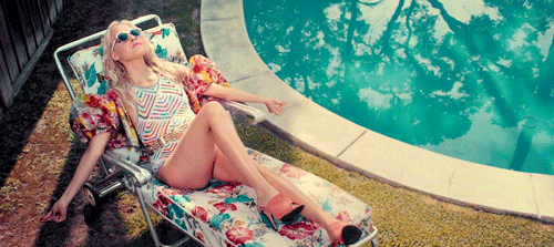 Gif of a woman shimmying on a pool chair.