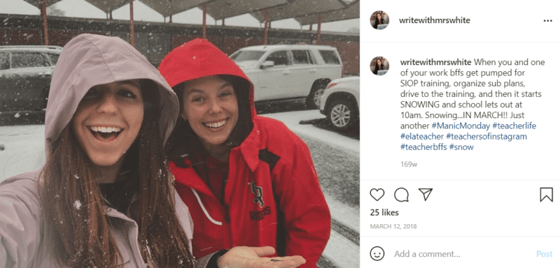 Two teachers standing in a snowy parking lot as snow falls