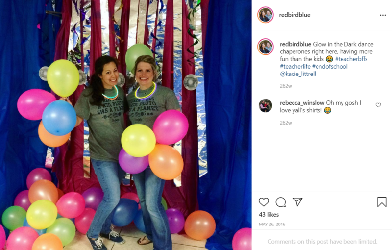 Two teachers pose with balloons while chaperoning school dance