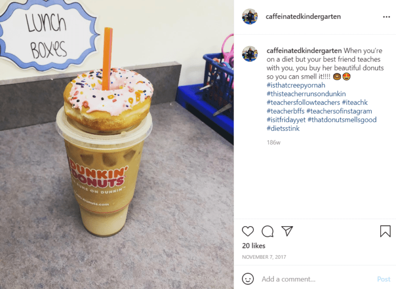 Dunking Donuts iced coffee with a donut on top sitting on teacher's desk