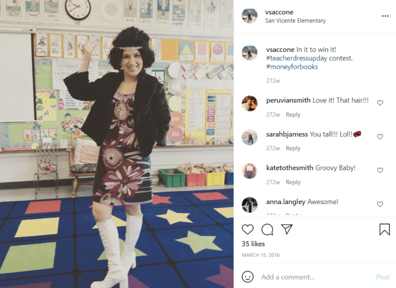 Teacher in a classroom dressed up like a flower child from the 70's in white knee-high boots, a dress, fur coat, and headband