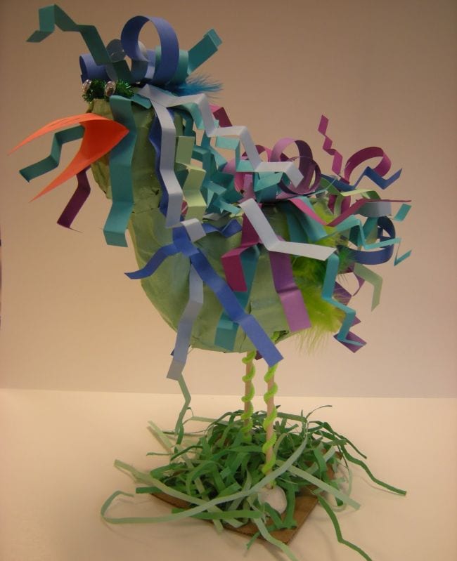 Papier-mache chicken adorned with paper strips