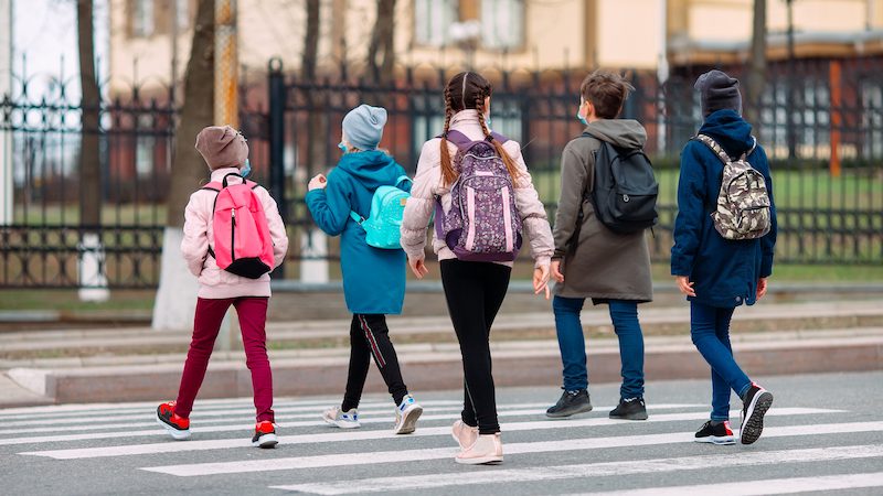 School children cross the road for a walking school bus.