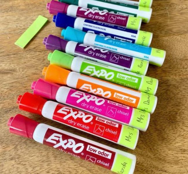 Dry erase markers labeled with green tape and a teacher's name (Whiteboard Hacks)
