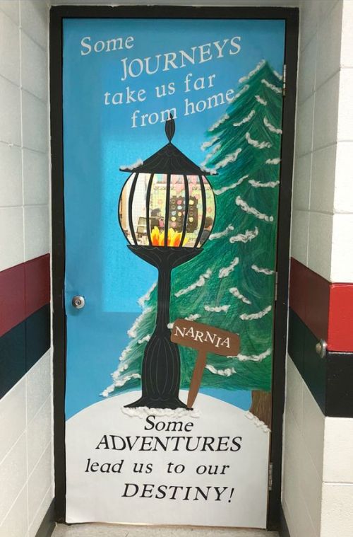 Classroom door decorated with a streetlight and snowy pine and a sign showing the way to Narnia