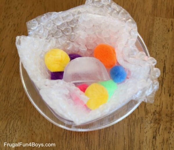 Colorful ice cubes sitting in a bowl with bubble wrap 