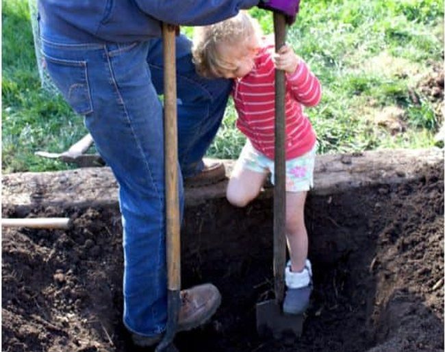 Woman and girl digging a hole to plant a tree