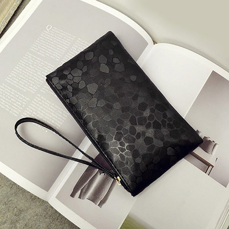 Black wristlet laying on a book 