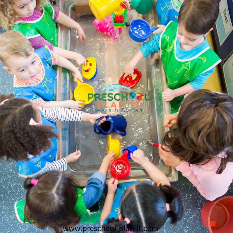 Group of preschool children playing in a water table, as an example of social-emotional activities